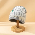 Bonnet en tricot gris avec lettrage graffiti et motifs d'étoiles vertes sur support - M (56-58cm) / Gris & Beige