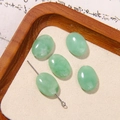 Macro detail of five oval pale green gemstone beads on a textured mat for DIY jewelry - Light Green Jade Look Oval Style (13号)