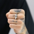 Close-up of men's titanium steel ring with geometric faceted cuts worn on a hand - US 7 / Steel