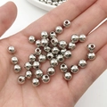 Detailaufnahme kleiner silberner CCB-Abstandshalter in der Handfläche für DIY-Schmuck - Weiß K Silber 6mm (2000 Stk)