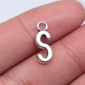 Detailed view of silver 'S' letter alloy charm held on finger for size scale - Letter S (B15672) / Antique Silver