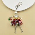 Detailed view of handmade doll keychain featuring red plaid skirt and pearl head detail - 18-Red Green Snowflake Doll