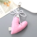 Pink PU leather heart keychain with white pearl bow and ribbon tag on a grey background - Pink