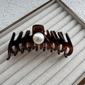 Detalle de una pinza de pelo de carey ámbar con perla central en una bandeja fina - Tamaño Grande 13cm