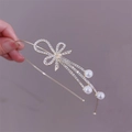 Detail of golden headband with rhinestone bow and dangling imitation pearl tassel charm - Bow Tie