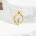 Macro shot of gold tulip relief on a round white shell pendant over white stone - Tulip Style (ZYN-DMK655G)