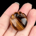 Tiger Eye stone cat paw carving with natural brown wood-grain texture and polished finish - Tiger's Eye