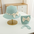Detail of light blue straw sun hat and matching crossbody bag with polka dot bow - Hat + Bag Set / Blue