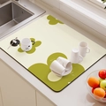 Close-up of beige absorbent dish drying mat with green floral patterns near kitchen sink - Dawn Green Grape