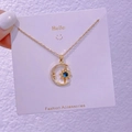 Dettaglio della collana con ciondolo luna e stella dorata con gemma blu su cartoncino - Gemma Luna Stella (XK0013)