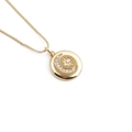 Minimalist gold star and moon necklace with sparkling pendant on a white background - Embossed Circular Star Moon