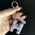 Macro view of letter H resin keychain with colorful heart sequins and butterfly charm - Letter H / Butterfly Tassel 8-Shape Buckle