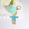 Letter T resin keychain with blue glitter finish and soft light green pom pom pendant - Letter T