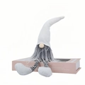 Gnomo natalizio nordico di peluche con lunghe gambe a strisce seduto su un libro rosa - Berretto in maglia bianco