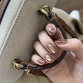 Unghie finte corte tonde occhio di gatto arancioni con glitter su mani femminili - Stile Occhio di Gato Ambra (JP4130)