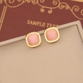 Pink cat eye stone square stud earrings with gold frame on a beige jewelry box - Stud Earrings