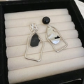 Macro shot of asymmetrical geometric silver earrings with black fill on satin texture - Silver Earring Post-Black