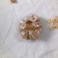Champagne satin silk scrunchie with smooth pleated texture on white fabric background - Champagne Gold
