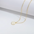 Golden necklace featuring a round white enamel pendant with a gold paw print relief design - White Dog Paw Print