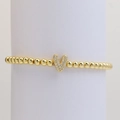 Elastic gold bead bracelet with crystal-paved bubble letter V pendant on white stand - Letter V