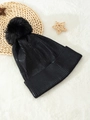 Close-up of black ribbed knit beanie with a large faux fur pompom on white fur background - One Size / Black