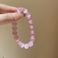 Macro detail of pink cat eye stone beads showing lustrous light reflection and smooth surface - 10mm Bead / Pink Cat Eye Stone
