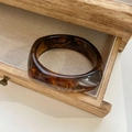Detail of amber tortoiseshell resin bangle with marble texture inside a wooden jewelry box - Inner Diameter 66mm / Amber