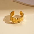 Close-up of golden adjustable ring with lava texture and abstract rose metal design - Rose Relief Style / Gold
