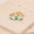 Primer plano de pendientes de flores en esmalte dorado con pétalos azules y blancos - Azul claro