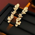 Pendientes dorados geométricos irregulares con diseño de lava sobre fondo de cuero negro - Pendientes Dorados (Pin de Plata)