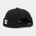 Dettaglio del cappello docker in denim nero con fibbia regolabile ed etichetta tessuta GR - Nero