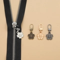 Macro shot of sakura-shaped metal zipper pulls in four colors for DIY garment repair - Sakura Shape - 4 Mixed Colors