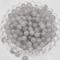 Top view of translucent grey round glass beads with holes in a clear tray for DIY jewelry - 4mm / Light Gray