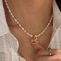 Collier élégant en perles et cheval doré porté sur mannequin pour un style vintage chic - Pendentif Cheval à Bascule Doré / Blanc (Plaqué Or)
