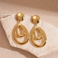 Macro shot of gold double-layered teardrop earrings on a textured stone surface - Gold