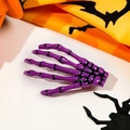 Macro detail of a purple skeleton hand hair clip on a festive Halloween theme background - Purple