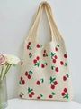 Close-up detail of knitted cherry pattern on a beige tote bag with a woven texture - Apricot