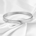 Primer plano de un brazalete pulido de 6mm de acero inoxidable sobre seda blanca fina - Color Acero