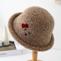 Detail of plush brown teddy wool bucket hat featuring a red velvet bow and animal face - 56-58cm / Khaki