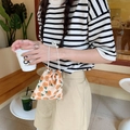 Primer plano de bolsa de pana con cordón en color beige con flores naranjas en la mano - Flor de Ciruelo Beige Tamaño Pequeño