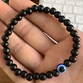 Elastisches 6mm Armband aus matten schwarzen Steinperlen mit blauem Evil Eye Anhänger - 6mm / Mattschwarz