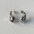Close-up of teardrop stainless steel stud earrings with high-polish mirror finish - Silver