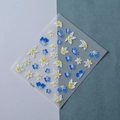 Vista macro di adesivi 3D per unghie con fiori blu e bianchi TS-099 con trama a rilievo - Stile Floreale Blu e Bianco in Rilievo (TS-099)