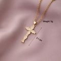 Close-up of gold-plated cross pendant with white zircons on a purple fabric background - Cross 10