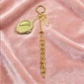 Portachiavi dorato per rossetto con nappa a fiocco su velluto rosa elegante - Portachiavi Rotondo d'Oro Stile Ovale