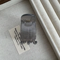 Close-up of a translucent smoky gray 5cm hair claw clip on a linen texture tray - Jelly Light Gray
