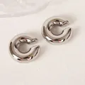 Macro shot of silver C-shaped clip-on earrings with high-polish mirror finish - Steel