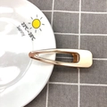 Detail of a minimalist gold hollow duckbill hair clip on a sun-patterned ceramic plate - 8cm Hollow Clip / Gold
