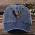 Detailed view of blue washed cotton baseball cap with eagle print on dark wood background - One Size / Navy Blue