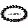 Macro shot of Taurus black onyx beads and yellow tiger eye stone with constellation symbol - Taurus